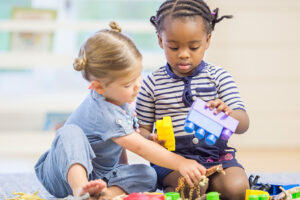 two_girls_sharing_blocks_during_play-300x200